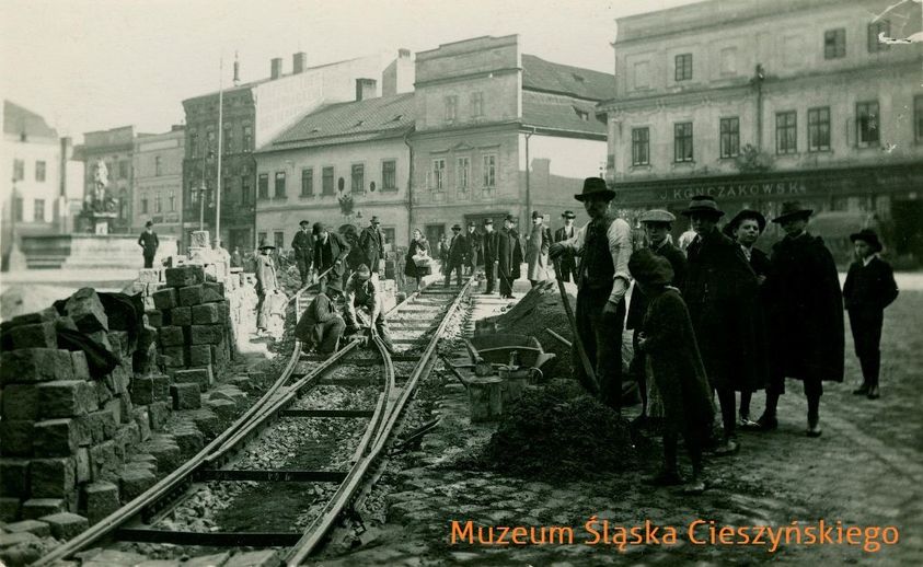 Archiwalne zdjęcie z zasobów Muzeum Śląska Cieszyńskiego, przedstawiający roboty remontowe na Rynku, które związane są z tworzeniem linii tramwajowej w Cieszynie na początku XX w.