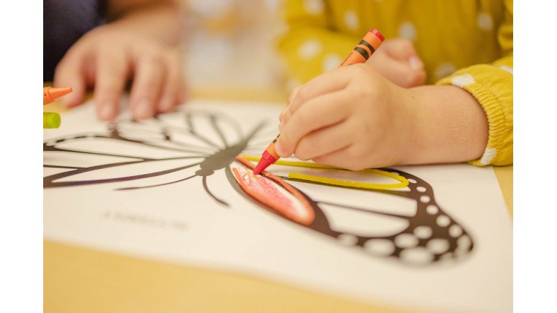 Dziecko w żółtej koszulce rysujące motyla, zdjęcie ilustracyjne, fot. Unsplash