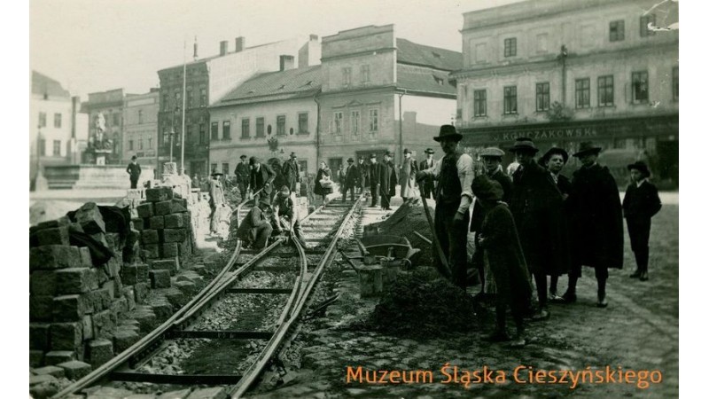 Archiwalne zdjęcie z zasobów Muzeum Śląska Cieszyńskiego, przedstawiający roboty remontowe na Rynku, które związane są z tworzeniem linii tramwajowej w Cieszynie na początku XX w.