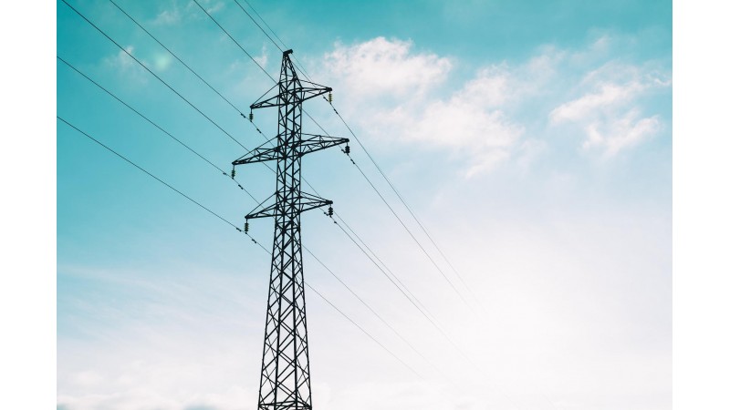 Słup wysokiego napięcia z przewodami elektrycznymi na tle niebieskiego nieba, zdjęcie przykładowe, źródło: Pixabay